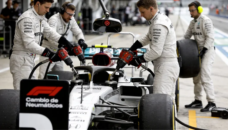 Mecánicos de Fórmula 1 ejecutando un pit stop relámpago cambiando los cuatro neumáticos